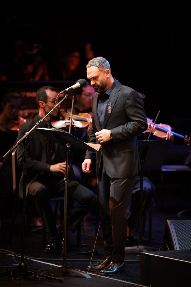 Milad Bagheri at the microphone with the orchestra