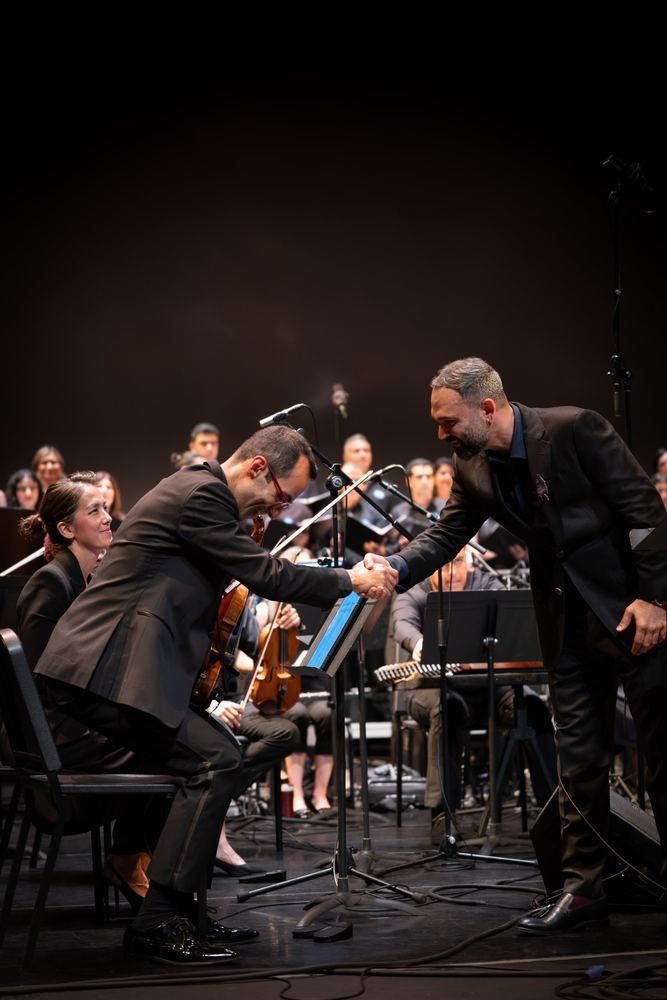 Milad Bagheri shaking hands with the concertmaster on stage