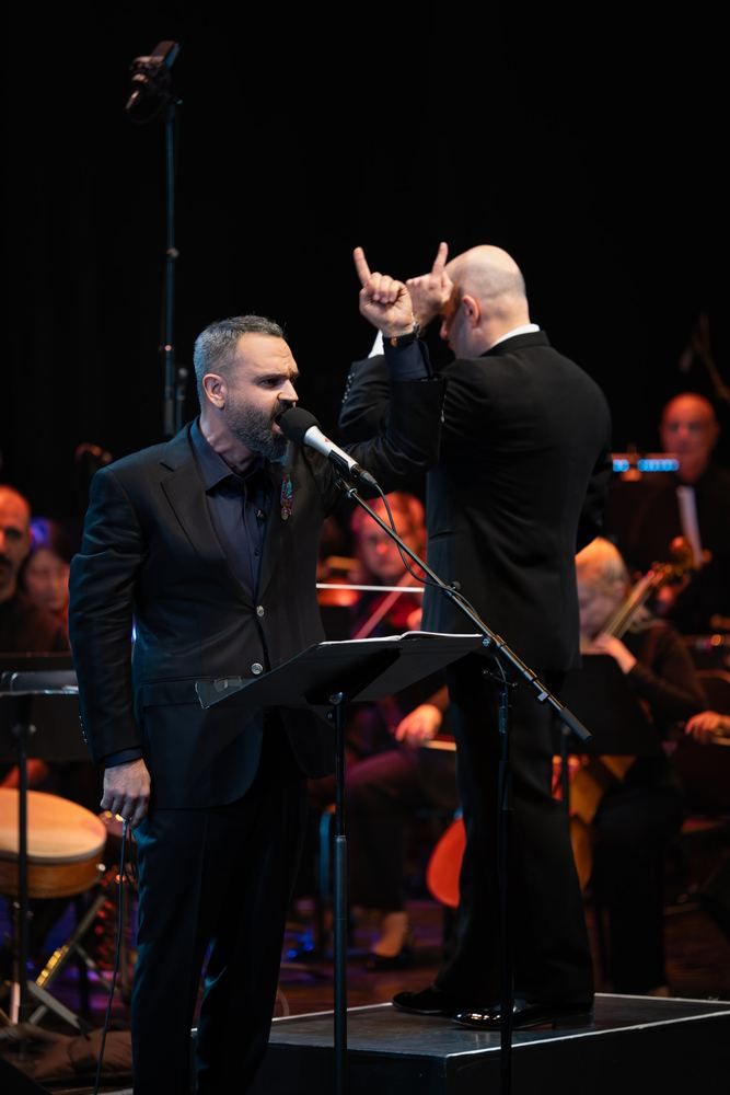 Milad Bagheri singing as soloist beside the conductor